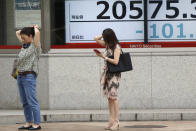 People stand by an electronic stock board of a securities firm in Tokyo, Wednesday, Aug. 21, 2019. Asia stock markets followed Wall Street lower Wednesday as investors looked ahead to a speech by the Federal Reserve chairman for signs of possible plans for more U.S. interest rate cuts. (AP Photo/Koji Sasahara)