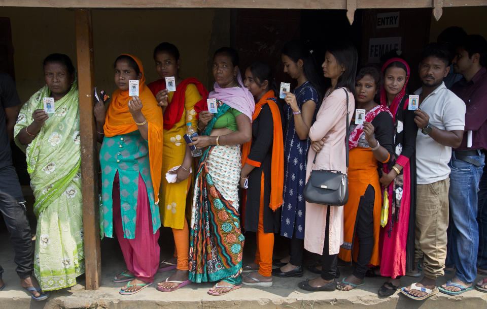 Indians show their voter identity card as they stand on queue to cast their votes during the third phase of the general election in Gauhati, India, Tuesday, April 23, 2019. Indians are voting Tuesday in the third phase of the general elections with campaigning by Prime Minister Narendra Modi's Hindu nationalist party and the opposition marred by bitter accusations and acrimony. The voting over seven phases ends May 19, with counting scheduled for May 23. (AP Photo/Anupam Nath)