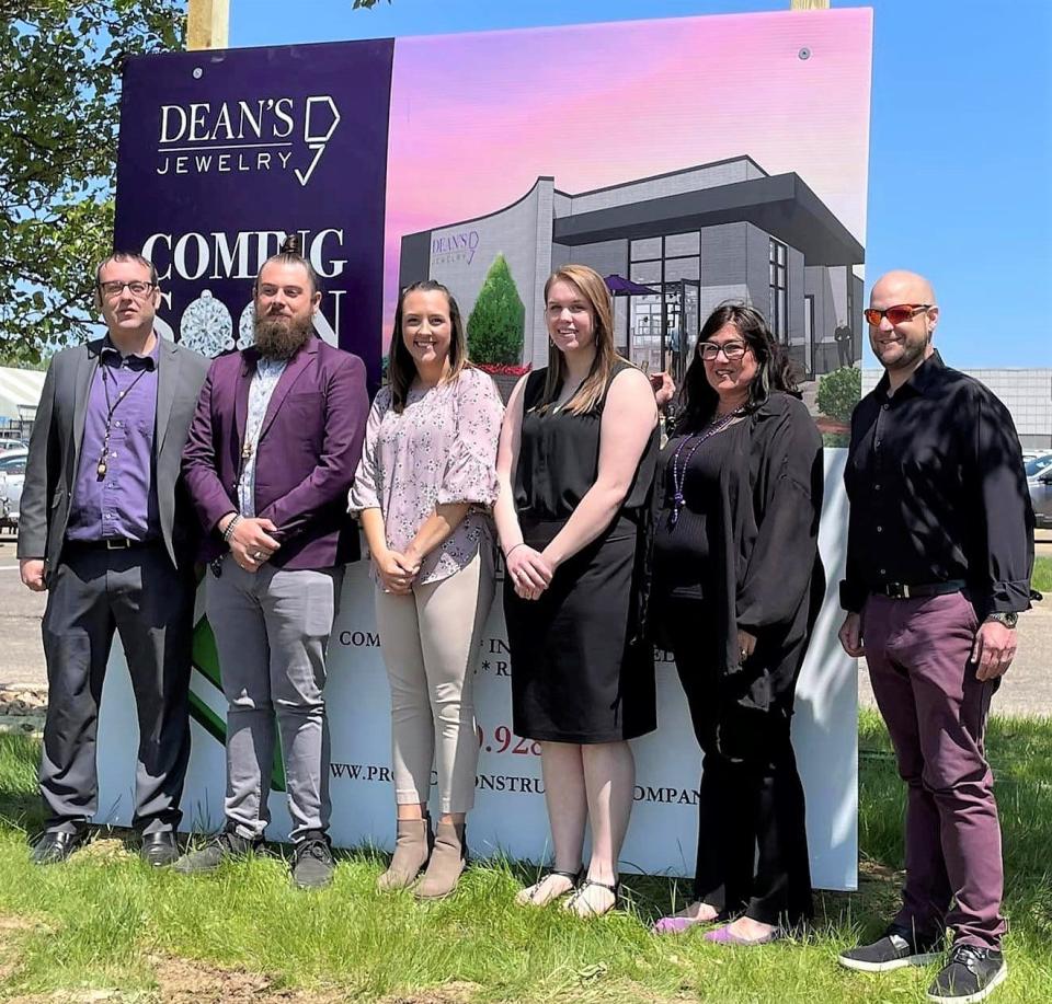 The Turner family in front of an artist rendering of a new building for its Mount Vernon location, which originally opened in 2007.