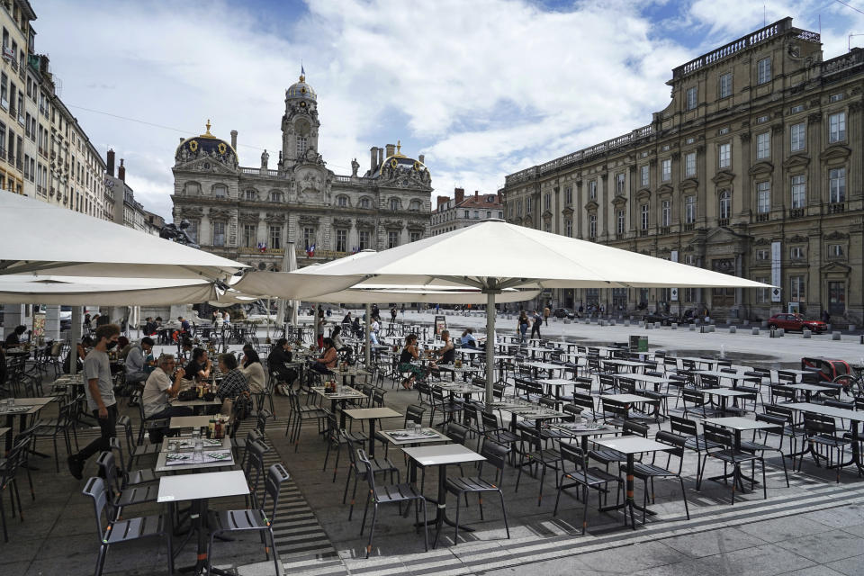 People eat and drink outdoors at a terrace bar in Lyon, central France, Tuesday, July 13, 2021. Nearly 1 million people in France made vaccine appointments in a single day, as the president cranked up pressure on everyone to get vaccinated to save summer vacation and the French economy. (AP Photo/Laurent Cipriani)