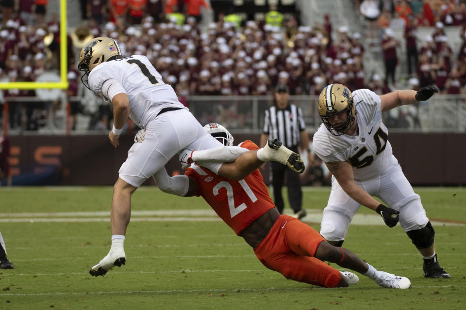 Purdue's Hudson Card (1) gets stopped by Virginia Tech's Keli Lawson (21) during an NCAA college football Saturday, Sept. 9 2023, in Blacksburg, Va. (AP Photo/Robert Simmons)