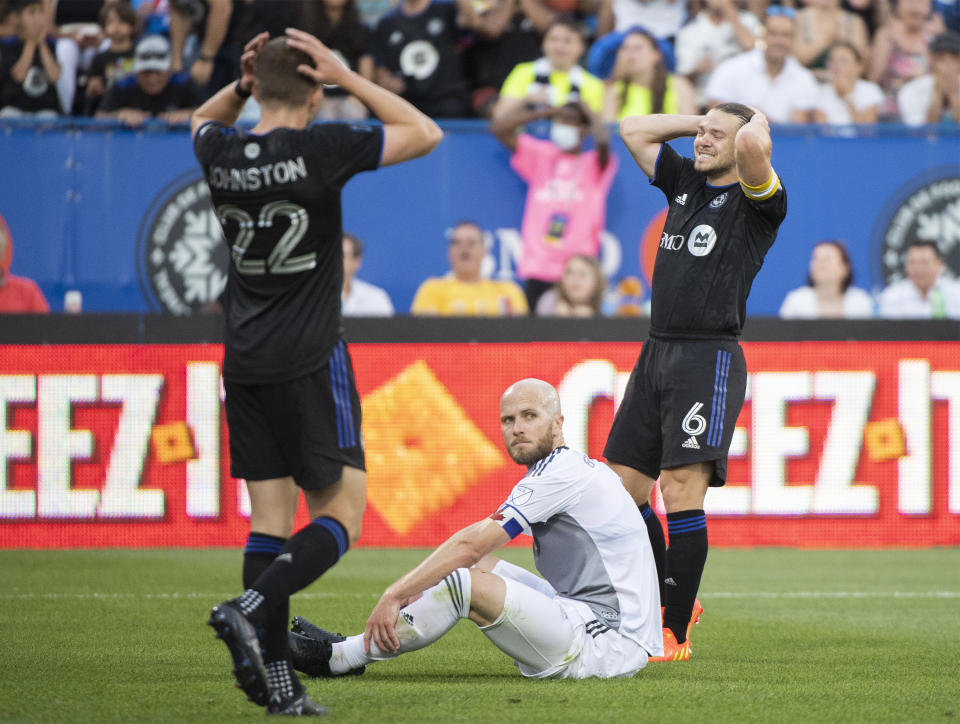 CF Montreal's Samuel Piette (6) and Alistair Johnston (22) react after an attempted shot, next to Toronto FC's Michael Bradley during the first half of an MLS soccer match Saturday, July 16, 2022, in Montreal. (Graham Hughes/The Canadian Press via AP)