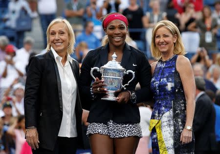 Serena Williams of the U.S. holds her trophy while flanked by tennis greats Martina Navratilova (L) and Chris Evert after Williams defeated Caroline Wozniacki of Denmark in their women's singles finals match at the 2014 U.S. Open tennis tournament in New York, September 7, 2014. REUTERS/Mike Segar