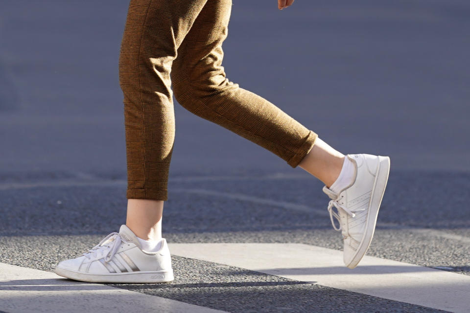 PARIS, FRANCE - JULY 08: A passerby wears brown cropped pants, white Adidas sneakers with silver stripes, on July 08, 2020 in Paris, France. (Photo by Edward Berthelot/Getty Images)