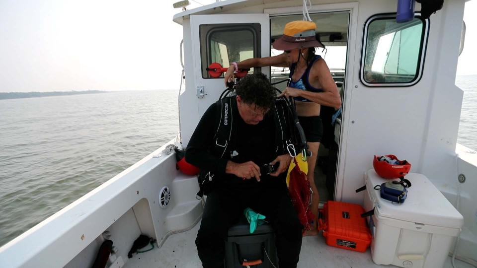 Bill Eberlein is assisted by his wife, Dodie Gay-Eberlein as he prepares to dive for megalodon teeth.