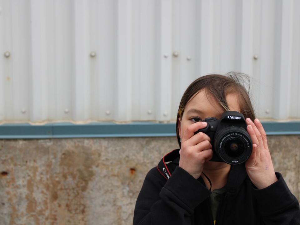 Isla Morris is captured mid-photograph by Abby Martin, a youth taking part in a Labrador In Focus workshop in Cartwright in May.  (Abby Martin - image credit)