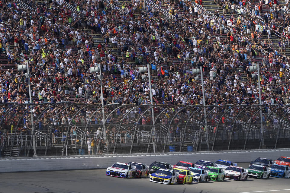 Kyle Larson, front left, leads the field to start the NASCAR Cup Series auto race at Michigan International Speedway, Sunday, Aug. 22, 2021, in Brooklyn, Mich. (AP Photo/Carlos Osorio)