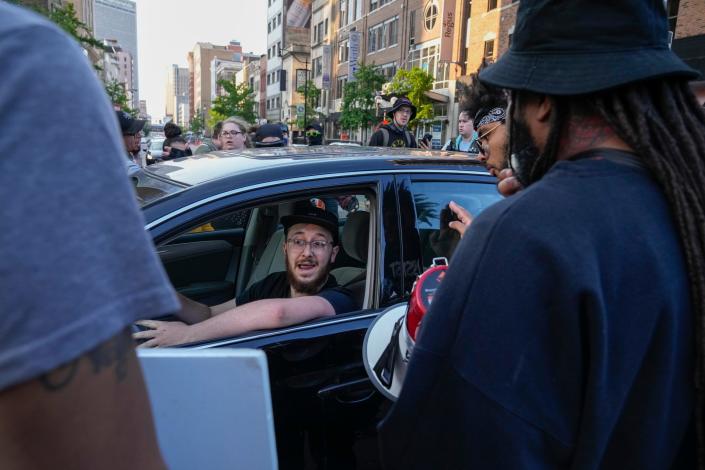 May 20, 2023; Columbus, Ohio, US;  A motorist engages with protestors as they march on South High Street during a protest for Sinzae Reed, a 13-year-old who was shot and killed in Columbus&#x002019; Hilltop neighborhood on Oct. 12, 2022 by Krieg Butler. A Franklin County grand jury recently declined to file murder charges for Butler. 