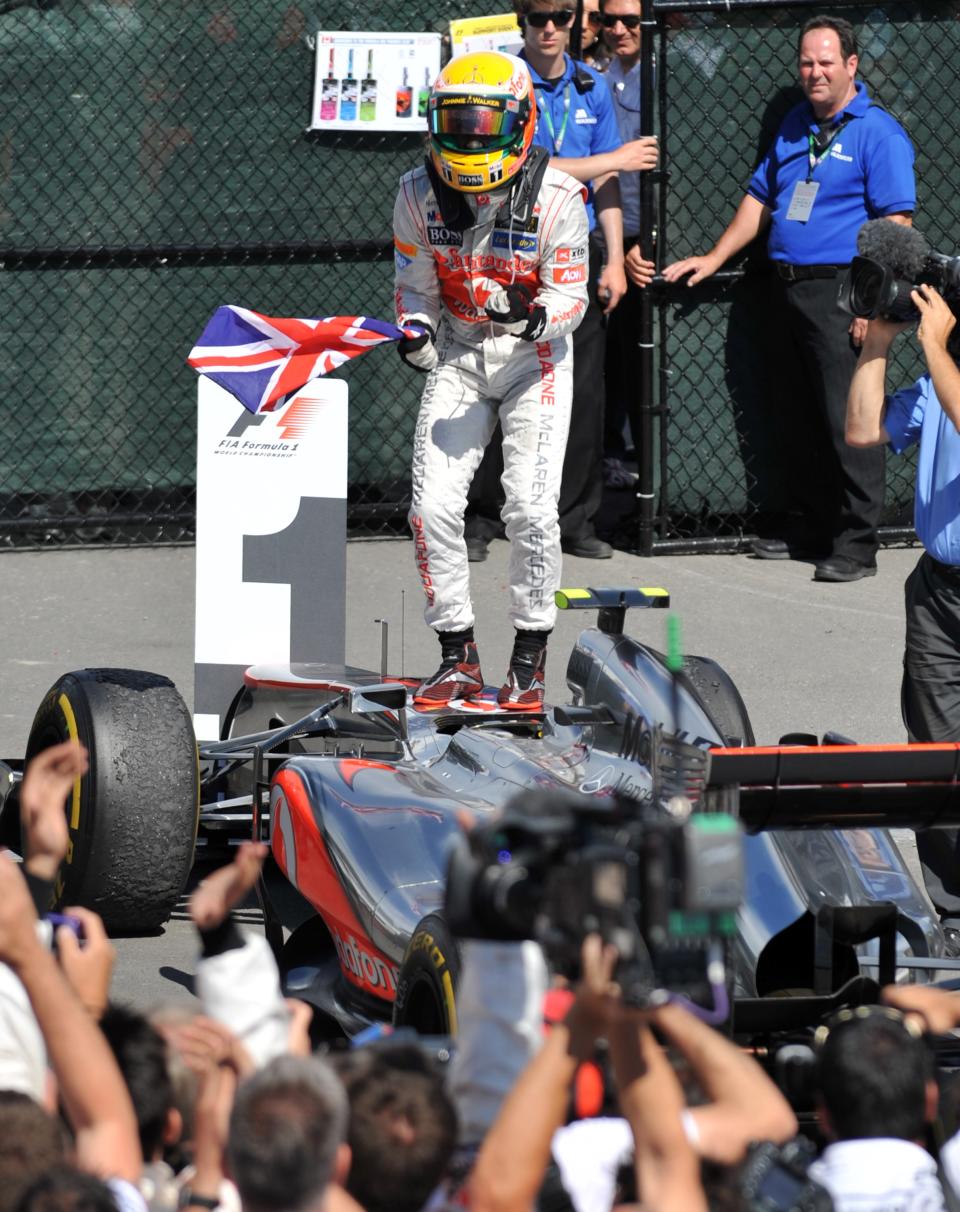 McLaren Mercedes driver Lewis Hamilton of Britain stands on his car as he celebrates his win in the Canadian Formula One Grand Prix on June 10, 2012 at the Circuit Gilles Villeneuve in Montreal. AFP PHOTO/Stan HONDASTAN HONDA/AFP/GettyImages
