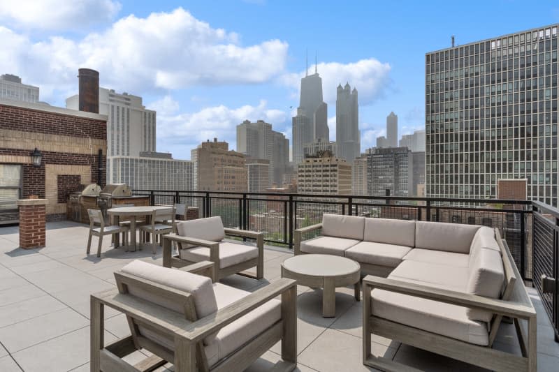 Deck of chicago condo with pale neutral outdoor furniture