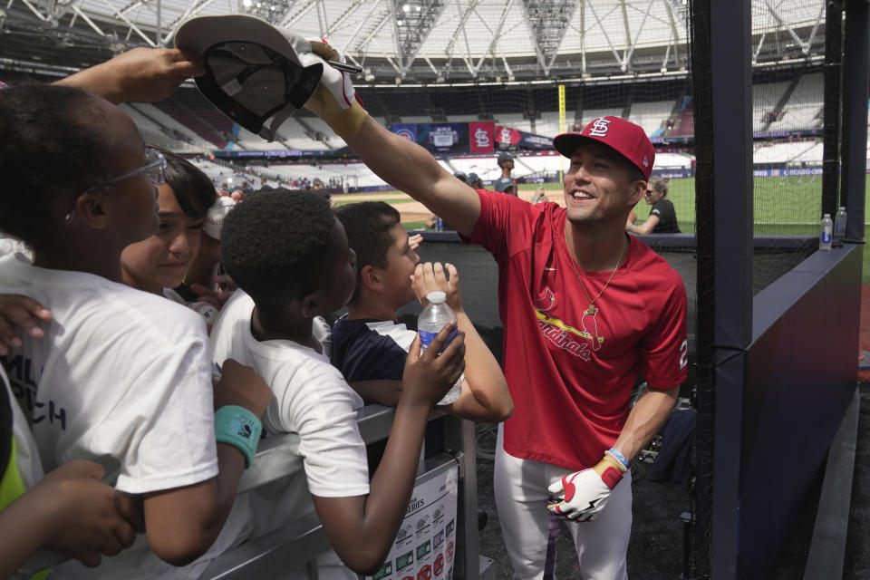 St. Louis Cardinals' Lars Nootbaar signs autograph to supporters during a training session ahead of the baseball match against Chicago Cubs at the MLB World Tour London Series, in London Stadium. (AP Photo/Kin Cheung)