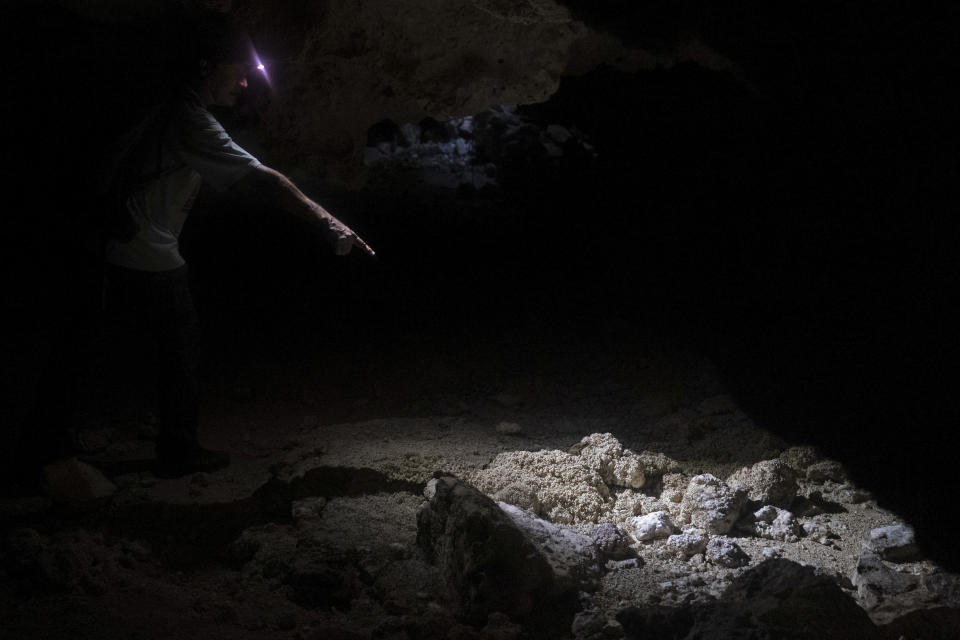 Raul Padilla, member of the Jaguar Wildlife Center which works to protect jaguars, points to a stalagmite while explaining the connections between the jungle and caves, inside the miles-long cave system "Garra de Jaguar," or the Paw of the Jaguar, underneath the planned route of the Maya Train in Playa del Carmen, Quintana Roo state, Thursday, Aug. 4, 2022. Mexican President Andres Manuel Lopez Obrador wants to finish the entire train in 16 months by filling the caves with cement or sinking concrete columns through the caverns – the only places that allowed humans to survive in this area. (AP Photo/Eduardo Verdugo)