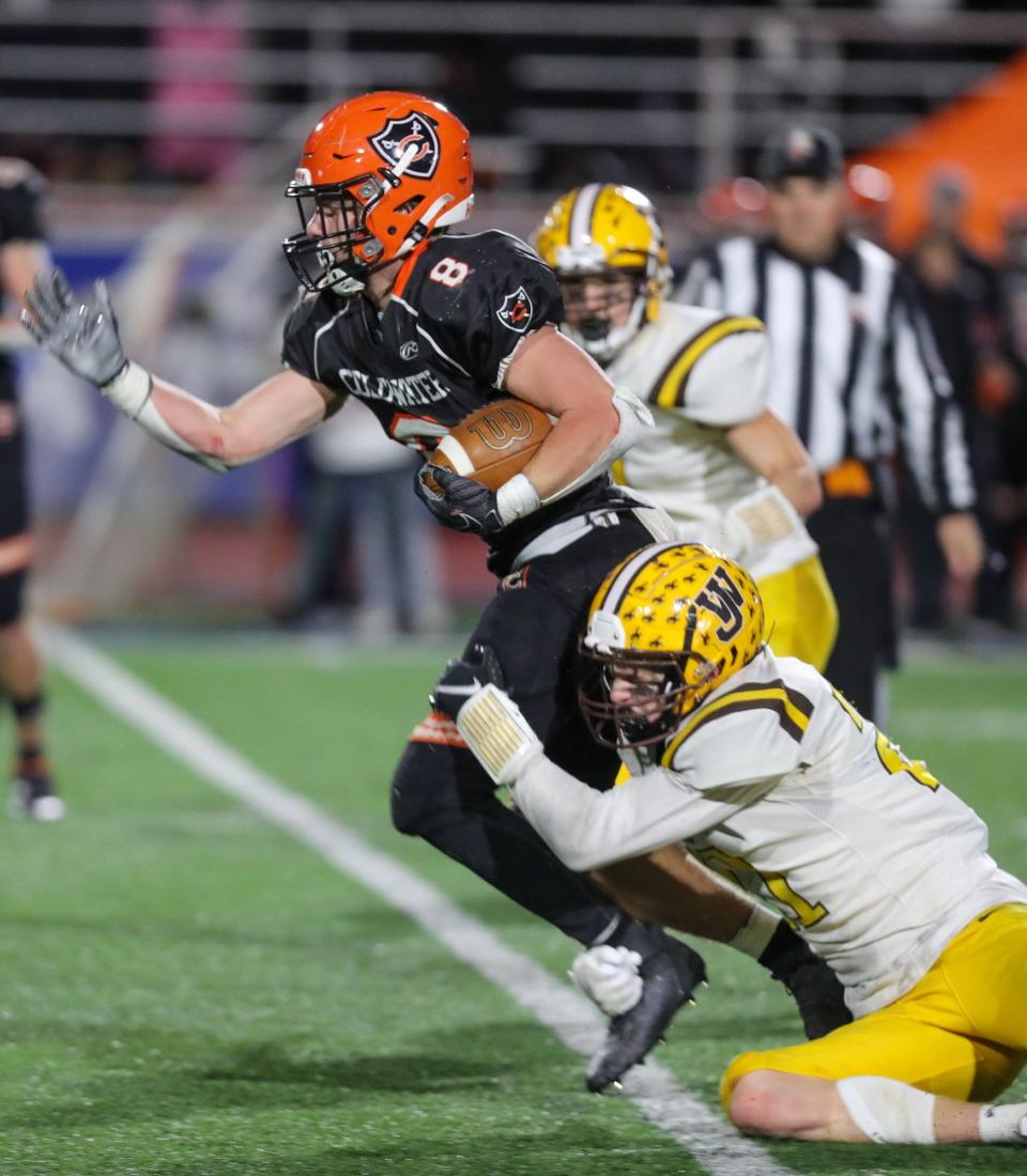 Coldwater's Isaac Fullenkamp is caught from behind by West Jefferson's M.J. Book during a Division VI state semifinal Nov. 27 at Piqua.