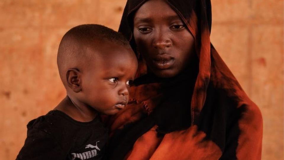 Kobra Yagoub-Sharaf with her daughter Eldin from Darfur pose for a portrait on the Chad Sudan border after having their documents processed on April 20, 2024 in Adre, Chad.