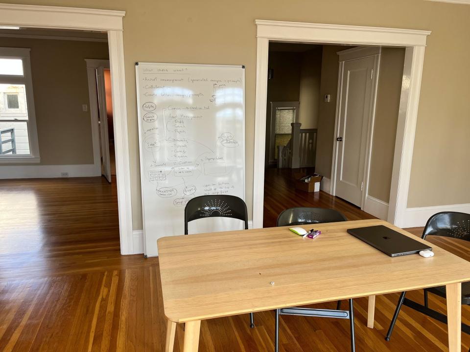 Picture of a bare apartment with a desktop and scattered items.