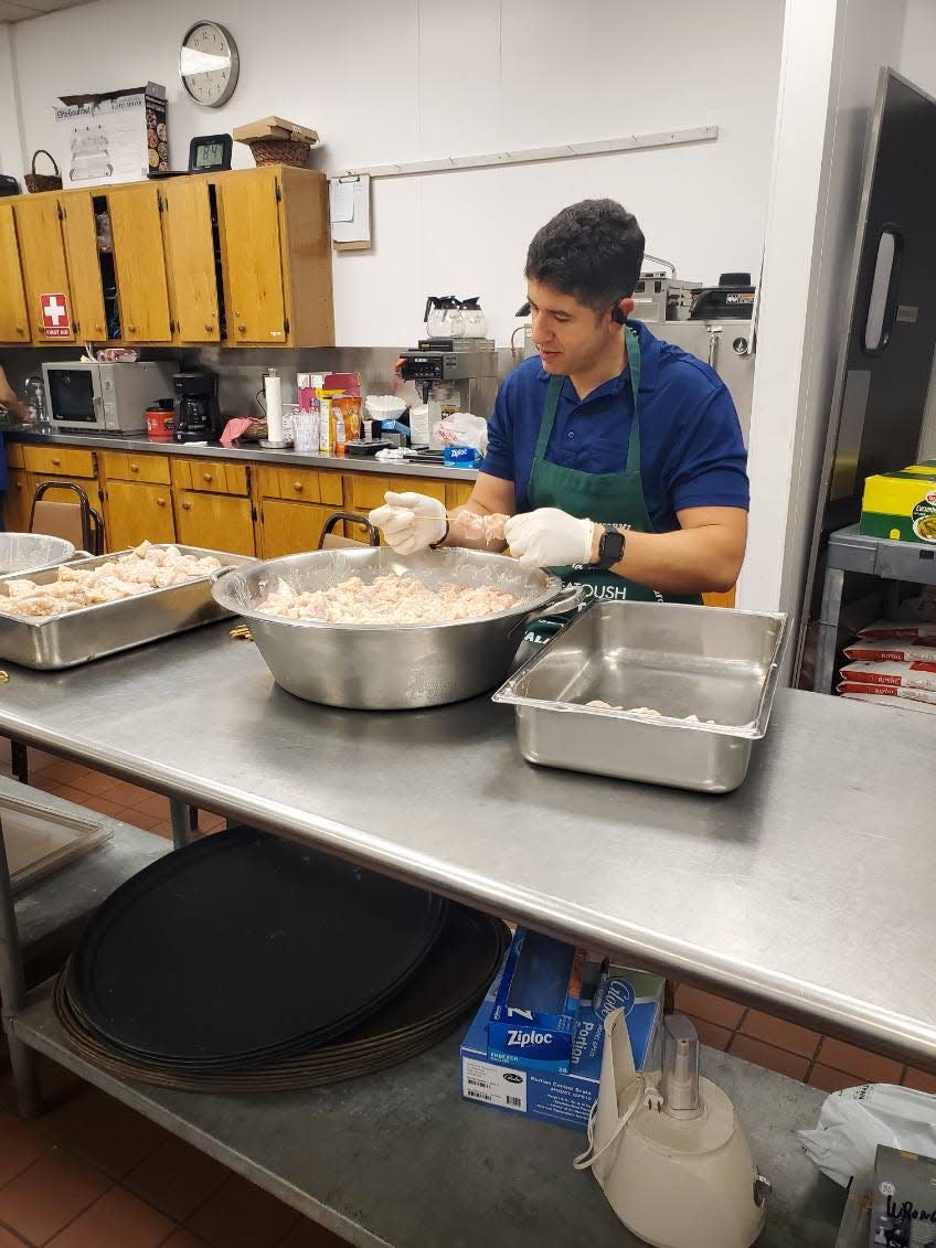 Our Lady of the Cedars parish priest Ronald Eid helps prepare food for the upcoming Lebanese Festival in Fairlawn.