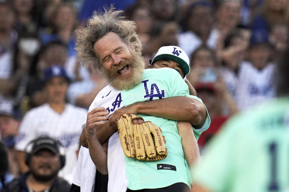 Los Angeles, CA - July 16:  Actor Bryan Cranston is hugged by Andre Either after catching a pop up by Adrian beltre in the first inning of the All-Star Celebrity Softball Game at Dodger Stadium in Los Angeles on Saturday, July 16, 2022. (Photo by Keith Birmingham/MediaNews Group/Pasadena Star-News via Getty Images)