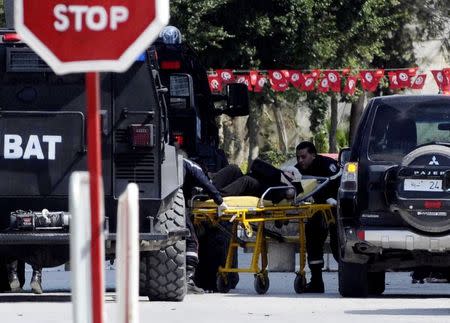 A tourist injured after an attack by gunmen on Tunisia's national museum is wheeled on a stretcher in Tunis March 18, 2015. REUTERS/Stringer