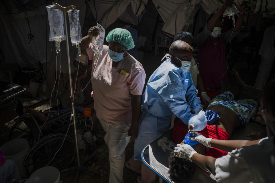 A nurse carries a saline drip as doctors try to save Stanley Joliva, a patient with cholera symptoms, at a clinic run by Doctors Without Borders in Port-au-Prince, Haiti, Thursday, Oct. 27, 2022. For the first time in three years, people in Haiti have been dying of cholera, raising concerns about a potentially fast-spreading scenario and reviving memories of an epidemic that killed nearly 10,000 people a decade ago. (AP Photo/Ramon Espinosa)