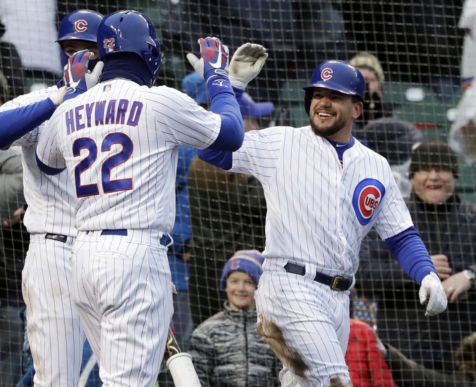 Cubs' runners Kyle Schwarber (right) and Jason Heyward celebrate after scoring on the same wild pitch during Saturday's wild win against the Braves. (AP)