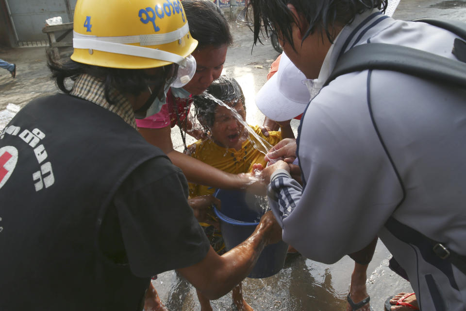 People hose their faces with water after tear gas was used in dispersing a protest in Mandalay, Myanmar on Saturday, Feb. 20, 2021. Security forces in Myanmar ratcheted up their pressure against anti-coup protesters Saturday, using water cannons, tear gas, slingshots and rubber bullets against demonstrators and striking dock workers in Mandalay, the nation's second-largest city. (AP Photos)