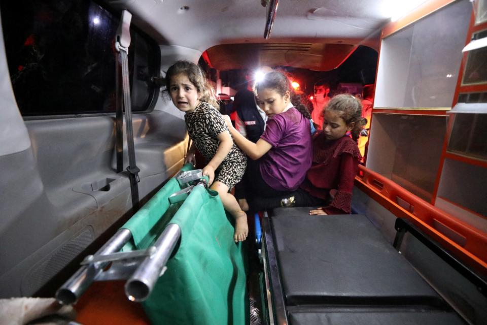 2023年10月17日，加薩阿里醫院遭轟炸，傷患送往希法醫院（Shifa Hospital）急救，驚恐的孩童坐在救護車上等待。路透社