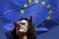 An anti-Brexit protestor and an EU flag are seen during protest in London, Saturday, Oct. 19, 2019. Britain's Parliament is set to vote in a rare Saturday sitting on Prime Minister Boris Johnson's new deal with the European Union, a decisive moment in the prolonged bid to end the Brexit stalemate. Various scenarios may be put in motion by the vote. (AP Photo/Kirsty Wigglesworth)