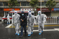 FILE - In this Sunday, Jan. 26, 2020 file photo, medical workers in protective gear help a patient near an ambulance in Wuhan in central China's Hubei Province.As Beijing instates one of the largest quarantines in modern history, locking down over 50 million people in Hubei province, questions are swirling around the provincial government's sluggish initial response. (Chinatopix via AP, File)