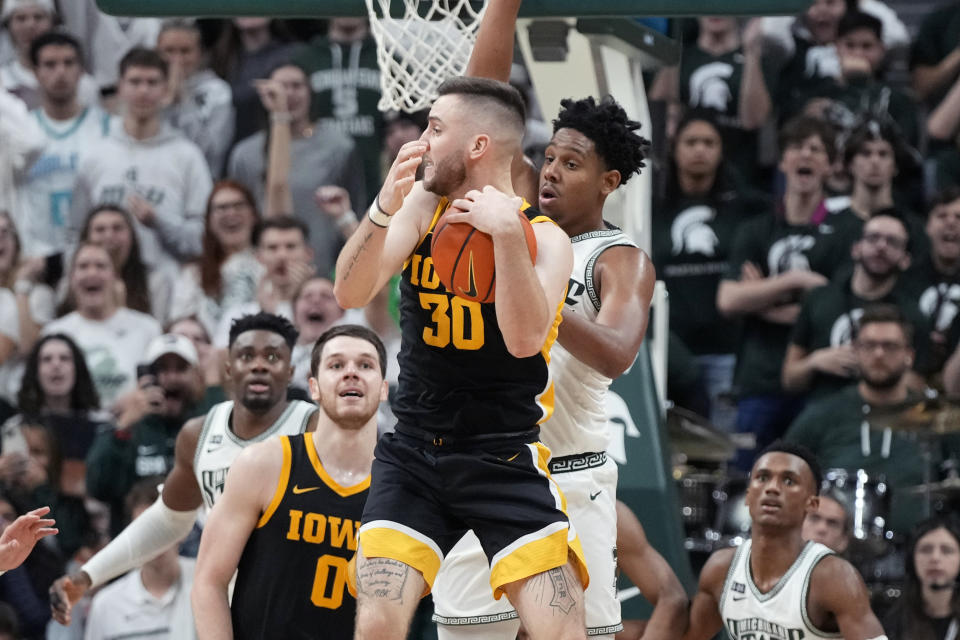 Iowa guard Connor McCaffery (30) looks to pass as he recovers the rebound during the last seconds of the second half of an NCAA college basketball game against Michigan State, Thursday, Jan. 26, 2023, in East Lansing, Mich. (AP Photo/Carlos Osorio)