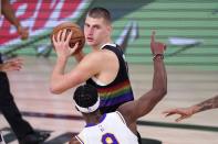 Denver Nuggets center Nikola Jokic, top, looks to make a pass as Los Angeles Lakers' Rajon Rondo (9) defends during the second half of Game 3 of the NBA basketball Western Conference final Tuesday, Sept. 22, 2020, in Lake Buena Vista, Fla. (AP Photo/Mark J. Terrill)