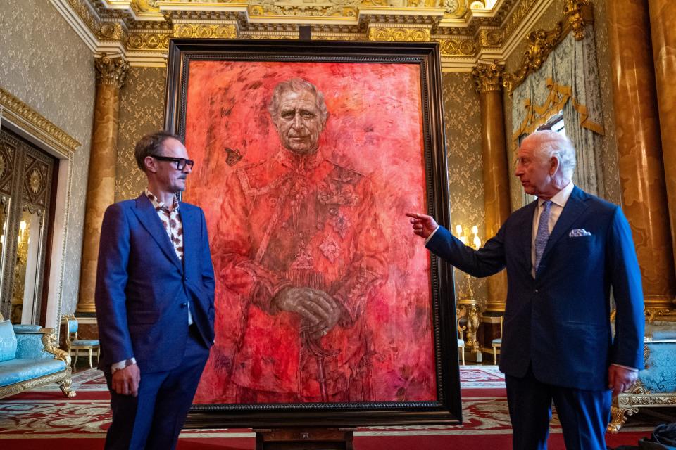 Jonathan Yeo and King Charles III stand in front of the artist's portrait of the King Charles III in the blue drawing room at Buckingham Palace on May 14, 2024 in London.
