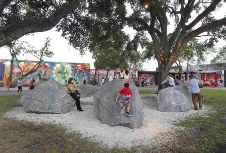 People are pictured at the Wynwood Walls during this month's Art Walk in the Miami neighborhood of Wynwood October 11, 2014. REUTERS/Andrew Innerarity