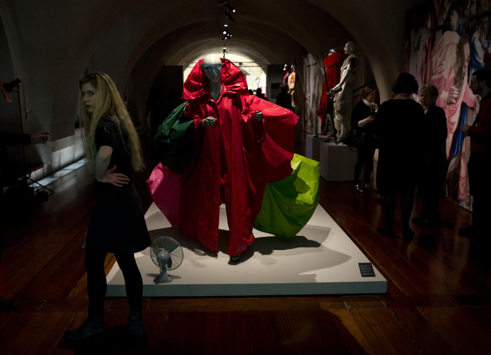 Items by different designers including Japanese designer Yoshiki Hishinuma's waxed plastic red, green, brown and pink wind coat, center, are displayed at the press view of the "Isabella Blow: Fashion Galore!" exhibition in London, Tuesday, Nov. 19, 2013. The exhibition, which runs from November 20 to March 2, celebrates the life and wardrobe of the late British patron of fashion and art who discovered many young fashion design talents. (AP Photo/Matt Dunham)