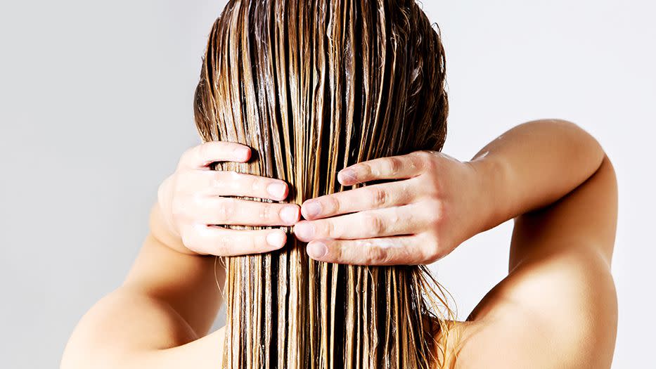 diy hair mask for dry hair: closeup of the back of a person's head as they massages in a hair mask