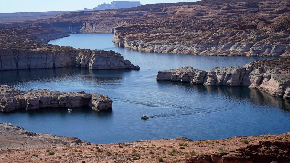 A boat cruises along Lake Powell near Page, Ariz., on July 31, 2021. Prolonged drought, climate change and overuse are jeopardizing the water supply that more than 40 million people rely on.
