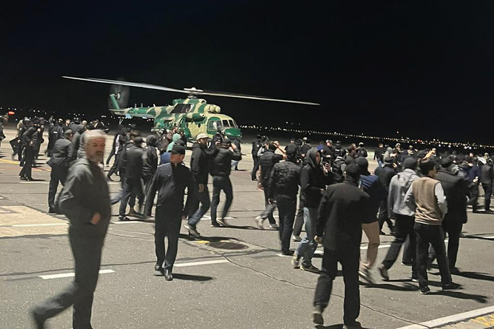 FILE – An angry crowd runs onto the tarmac at the airport in Makhachkala, Russia, the provincial capital of the Dagestan republic, on Monday, Oct. 30, 2023, as a flight arrives from Israel. Some in the crowd carried banners with antisemitic slogans. Jews in the predominantly Muslim region of Dagestan in southern Russia say they are determined to regroup and rebuild following a deadly attack by Islamic militants on June 23 on Christian and Jewish houses of worship in Derbent and the regional capital of Makhachkala.. (AP Photo, File)