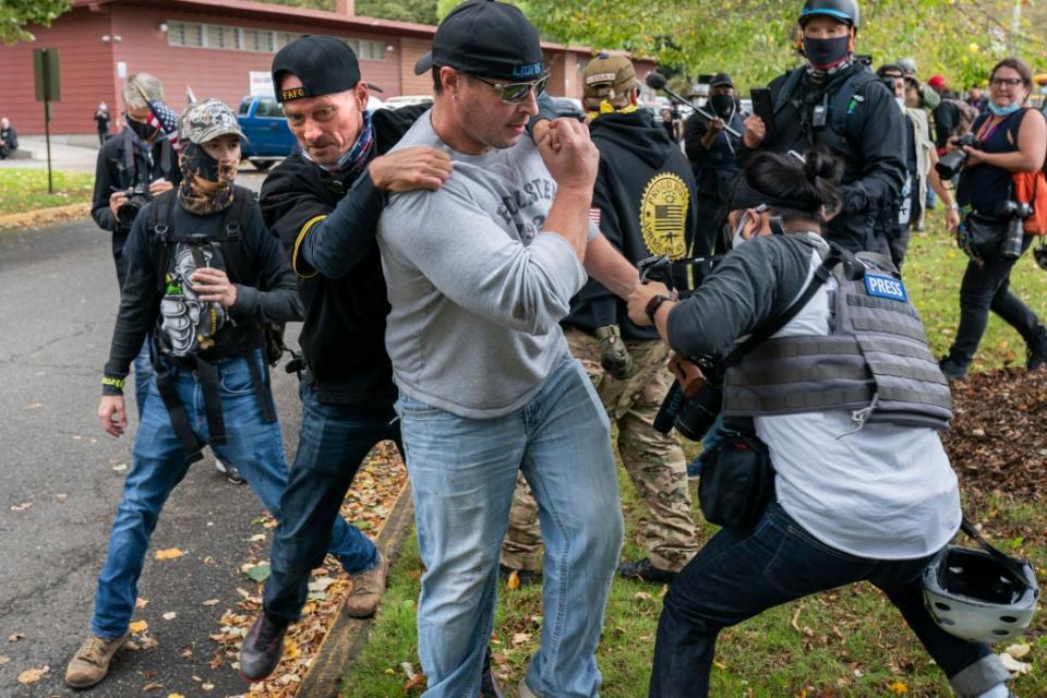 A Proud Boys member pulls away another who was assaulting a freelance journalist in Portland, Oregon, last week. (Getty Images)