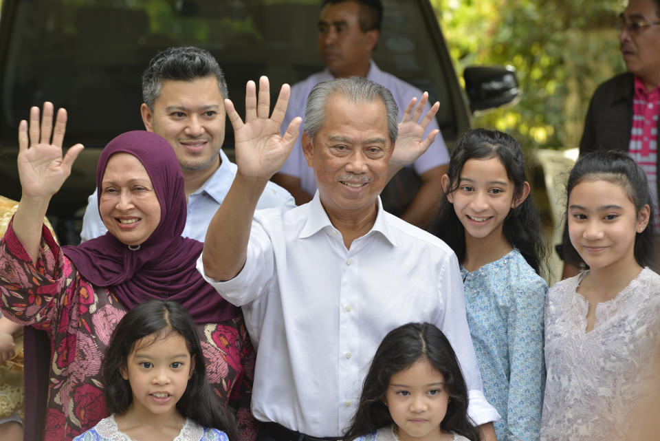 Politician Muhyiddin Yassin, center, waves to media after outside his house after he being appointed as the new prime minister in Kuala Lumpur, Malaysia, Saturday, Feb. 29, 2020. Malaysia's king has appointed seasoned politician Muhyiddin Yassin as the new prime minister, trumping Mahathir Mohamad's bid to return to power after a week of political turmoil that followed his resignation as prime minister. (AP Photo/John Shen Lee)