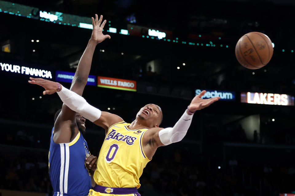 Los Angeles Lakers guard Russell Westbrook (0) is fouled by Golden State Warriors forward Draymond Green during the first half of an NBA basketball game in Los Angeles, Tuesday, Oct. 19, 2021. (AP Photo/Ringo H.W. Chiu)