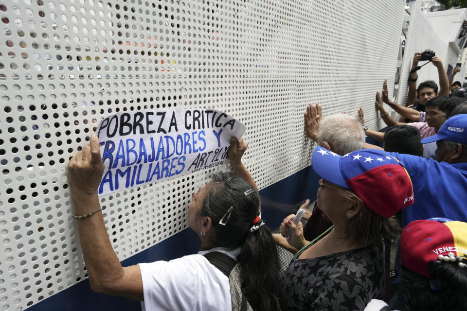 Una barrera policial impide que los manifestantes lleguen a la Fiscalía durante su marcha por el Día del Trabajo, en Caracas, Venezuela, el lunes 1 de mayo de 2023. (AP Foto/Ariana Cubillos)