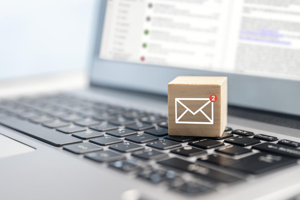 Email symbol on wooden block showing new message on laptop keyboard