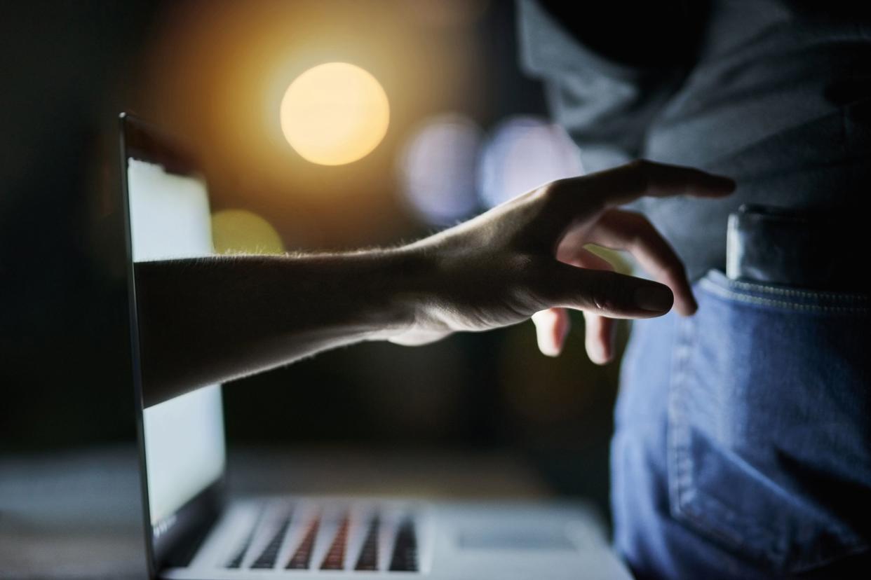 hand coming out of laptop taking man's wallet