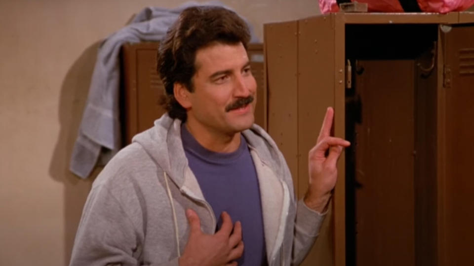 Keith Hernandez wearing a sweatshirt, leaning on a locker in Seinfeld.