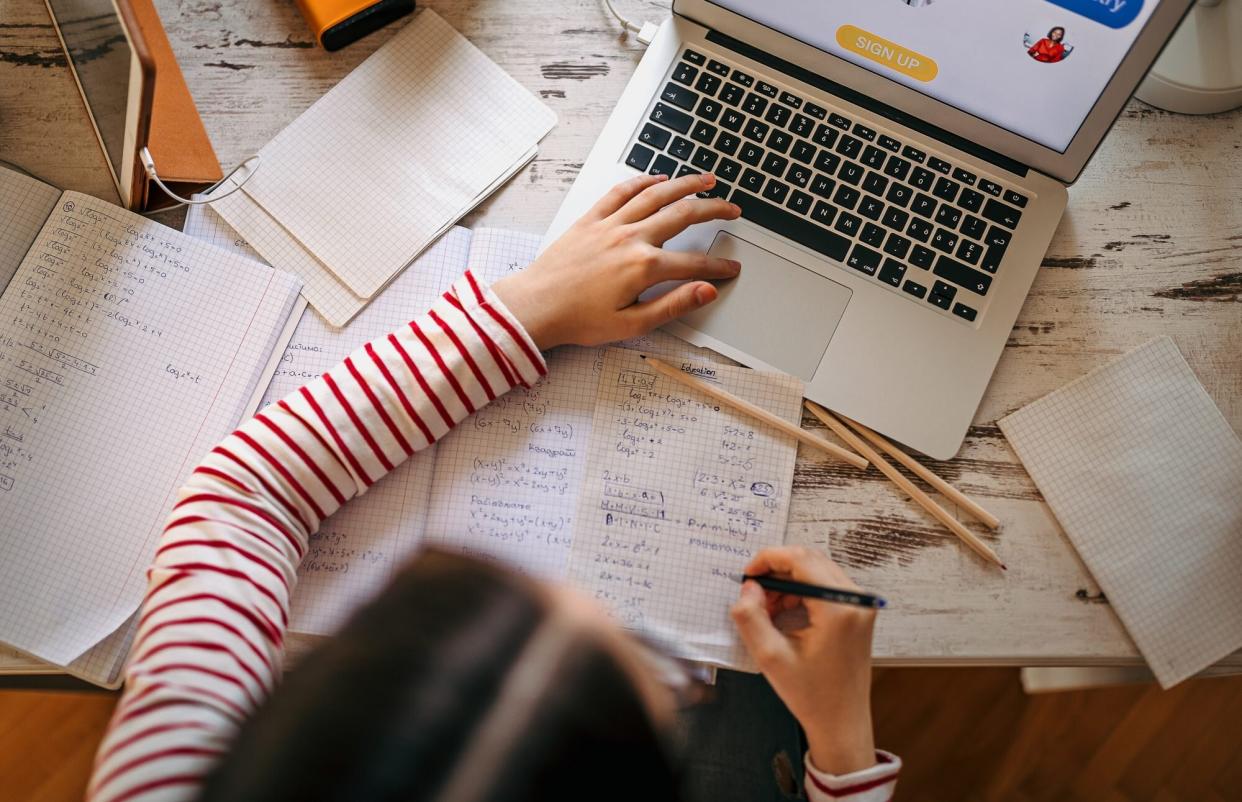 An image of a teenage girl using studying tools online.