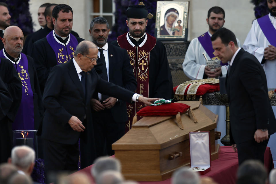 Lebanese President Michel Aoun, places medals on the coffin of former Maronite Patriarch Cardinal Mar Nasrallah Boutros Sfeir, during his funeral Mass, at the seat of the Maronite Church, in the village of Bkirki, north of Beirut, Lebanon, Thursday, May 16, 2019. Sfeir, who served as spiritual leader of Lebanon's largest Christian community through some of the worst days of the country's 1975-1990 civil war, died Sunday. (AP Photo/Bilal Hussein)