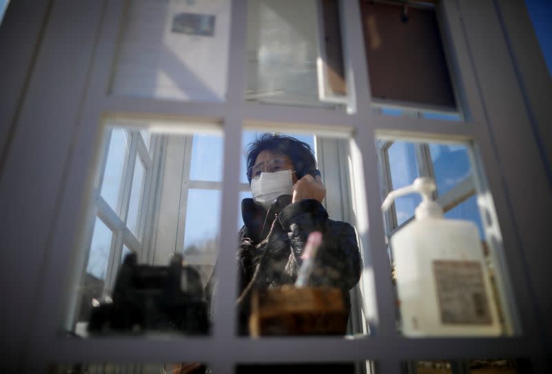 The Wider Image: Japan's tsunami survivors call lost loves on the phone of the wind