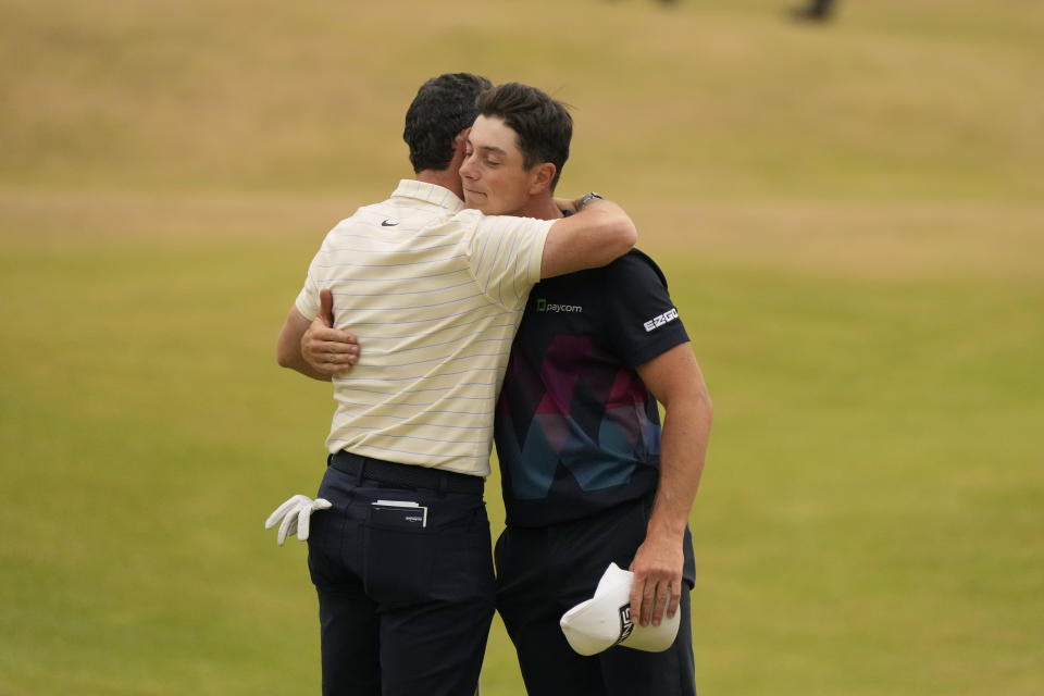 Rory McIlroy of Northern Ireland, left, and Viktor Hovland, of Norway, on the 18th green after finishing their final round of the British Open golf championship on the Old Course at St. Andrews, Scotland, Sunday July 17, 2022. (AP Photo/Gerald Herbert)