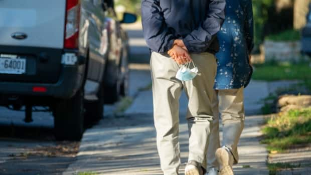 A person carries their mask on a walk in Ottawa on Sept. 13, 2021 during the COVID-19 pandemic.  (Francis Ferland/CBC - image credit)