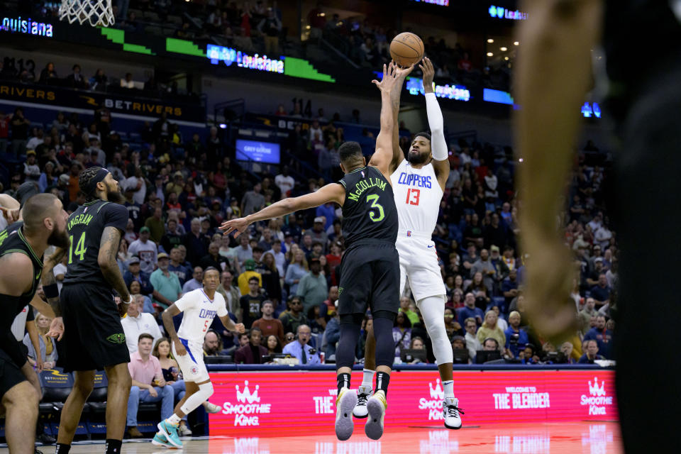 Los Angeles Clippers forward Paul George (13) goes up to shoot against New Orleans Pelicans guard CJ McCollum (3) during the first half of an NBA basketball game in New Orleans, Friday, March 15, 2024. (AP Photo/Matthew Hinton)