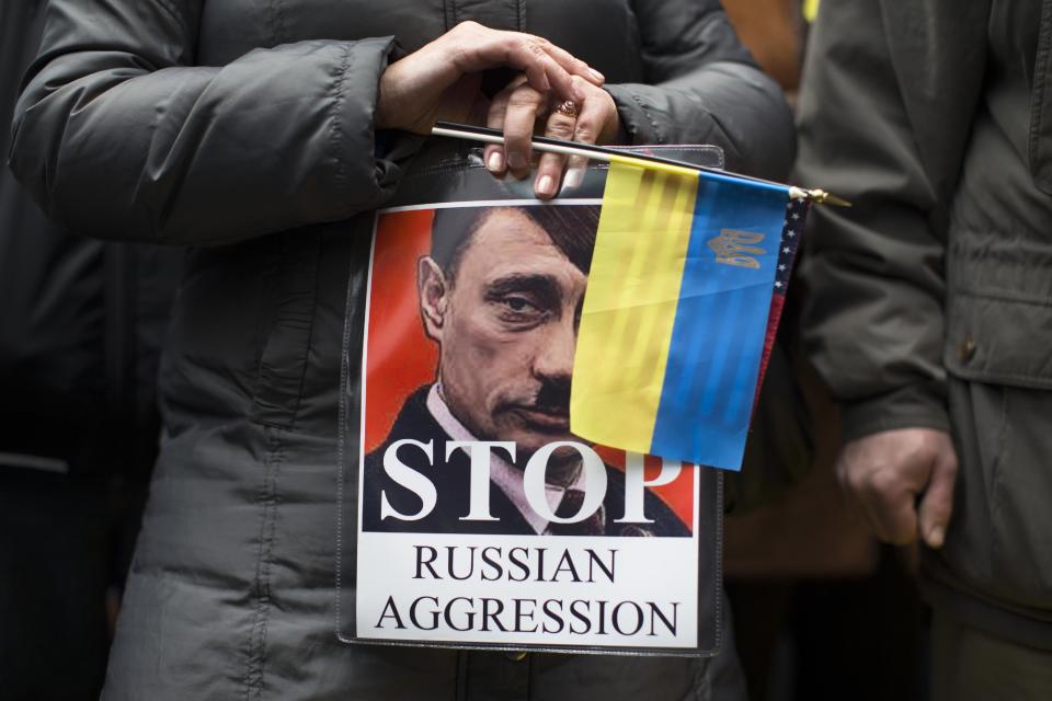 Demonstrators against Russian military actions in Ukraine rally in Times Square, Sunday, March 2, 2014, in New York. Western powers are prepared "to go to the hilt" to isolate Russia for its military incursion into Ukraine, "an incredible act of aggression" that may lead to visa bans, asset freezes, trade and investment penalties, and a boycott of a Russian-hosted economic summit of global powers in June, Secretary of State John Kerry said Sunday. (AP Photo/John Minchillo)